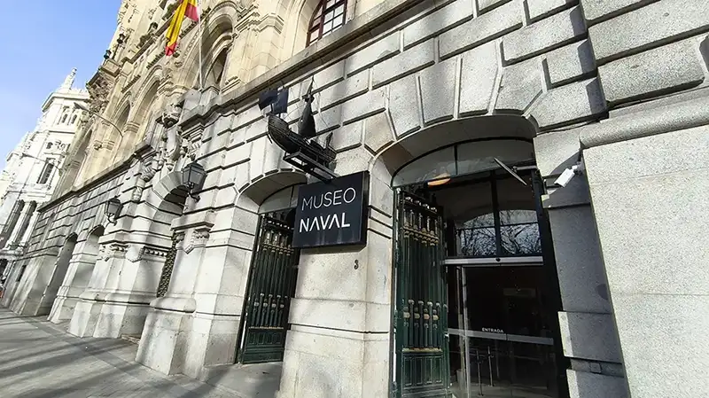Entrada do Museo Naval de Madrid com letreiro e escultura de navio na fachada de pedra