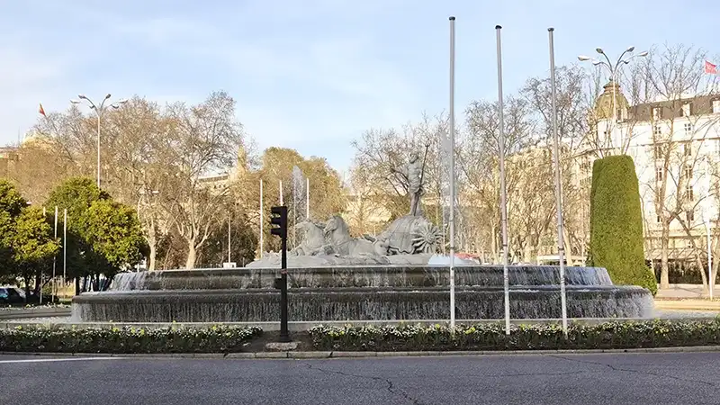 Fonte de Neptuno na Plaza de Cibeles com árvores sem folhas ao fundo, Madrid