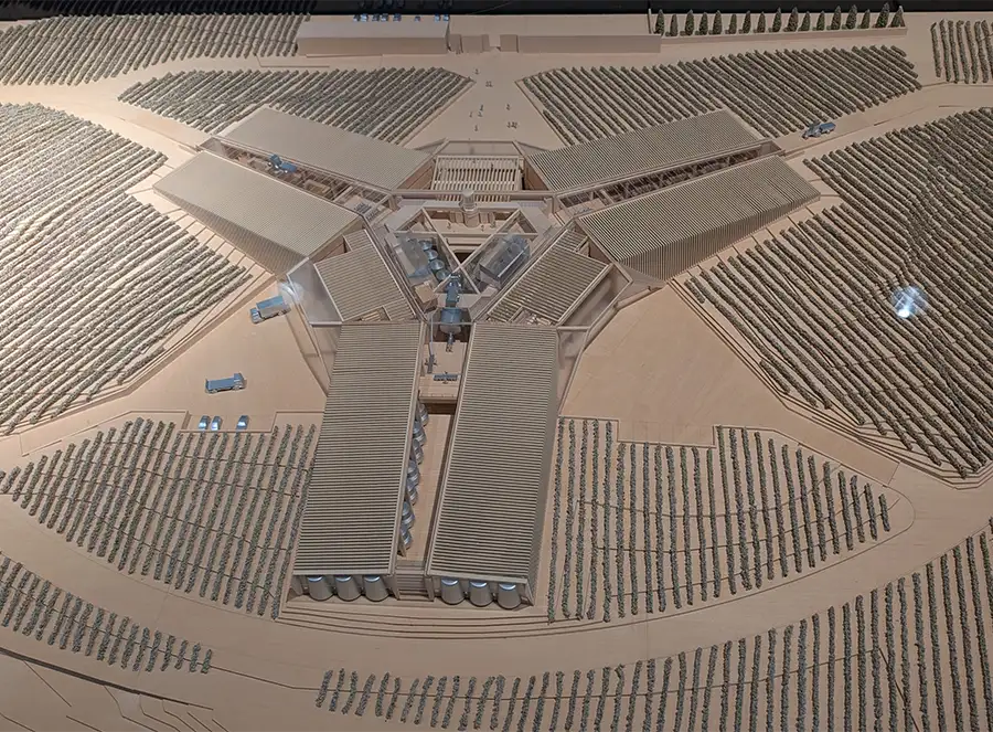 Maquete arquitetônica do edifício em forma de estrela de três pontas da Bodegas Portia visto de cima, cercado por vinhedos.