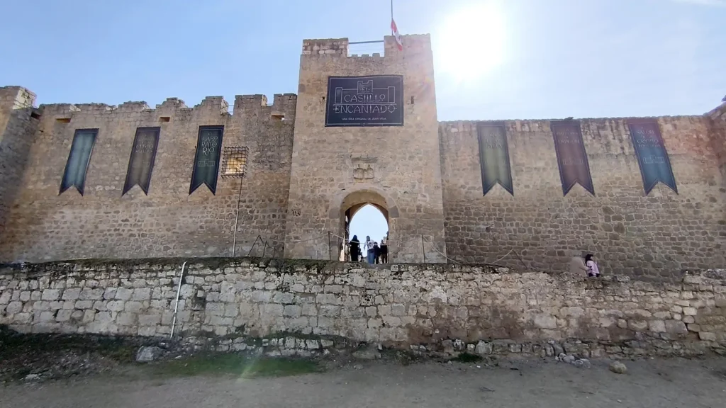 Fachada de pedra do Castillo Encantado em Trigueros del Valle com placas da exposição de Juan Villa.