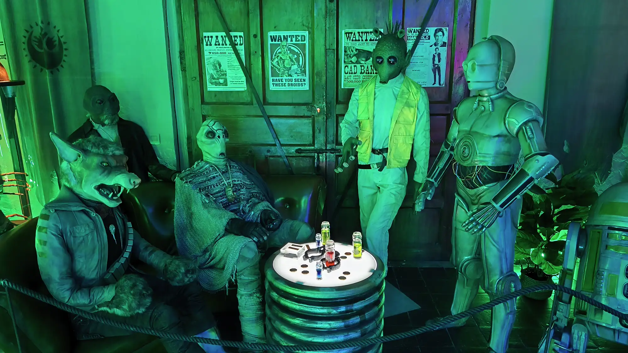 Réplicas realistas de alienígenas y droides de la saga Star Wars bajo luces verdes en el museo Puerto Espacial de Valoria la Buena.