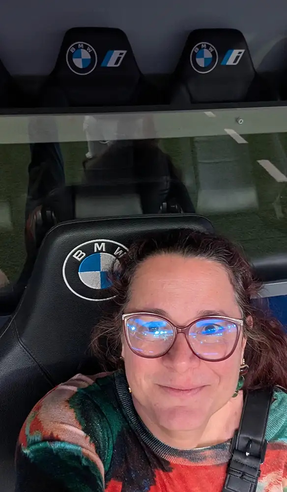 Selfie em plano fechado mostrando o encosto de cabeça em couro preto de um dos assentos do banco de reservas com o logotipo da BMW.
