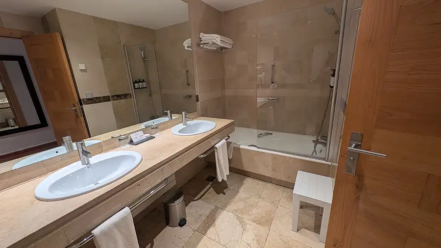 Banheiro do Parador de Toledo com duas pias, banheira e revestimento em mármore