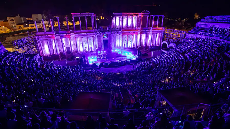 Show do Stone & Music Festival no Teatro Romano de Mérida à noite, com a scaena iluminada em roxo e o teatro lotado de público