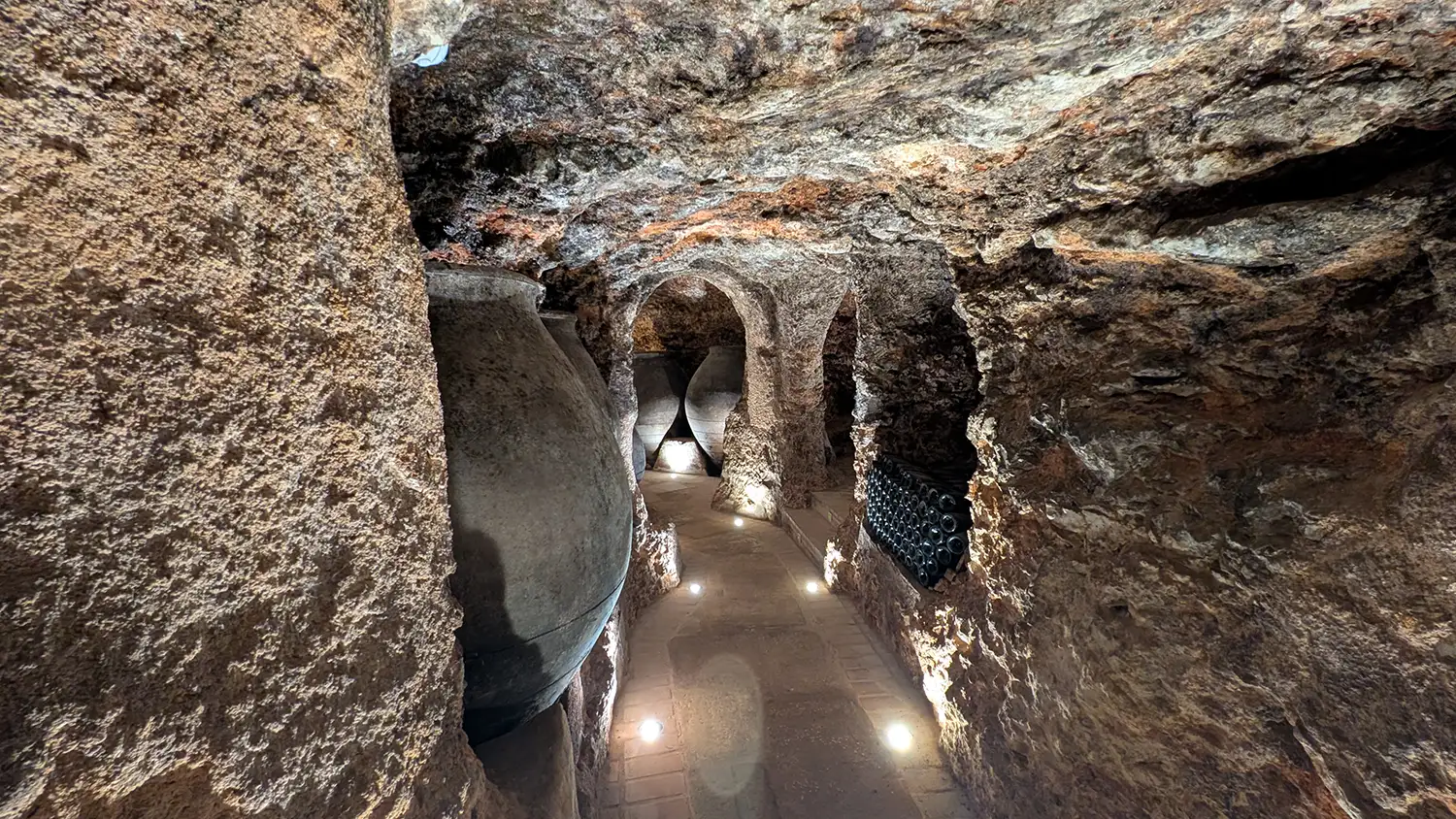 Caverna de vinho da Bodega Pedro García em Colmenar de Oreja, com paredes de pedra calcária e corredor subterrâneo iluminado.