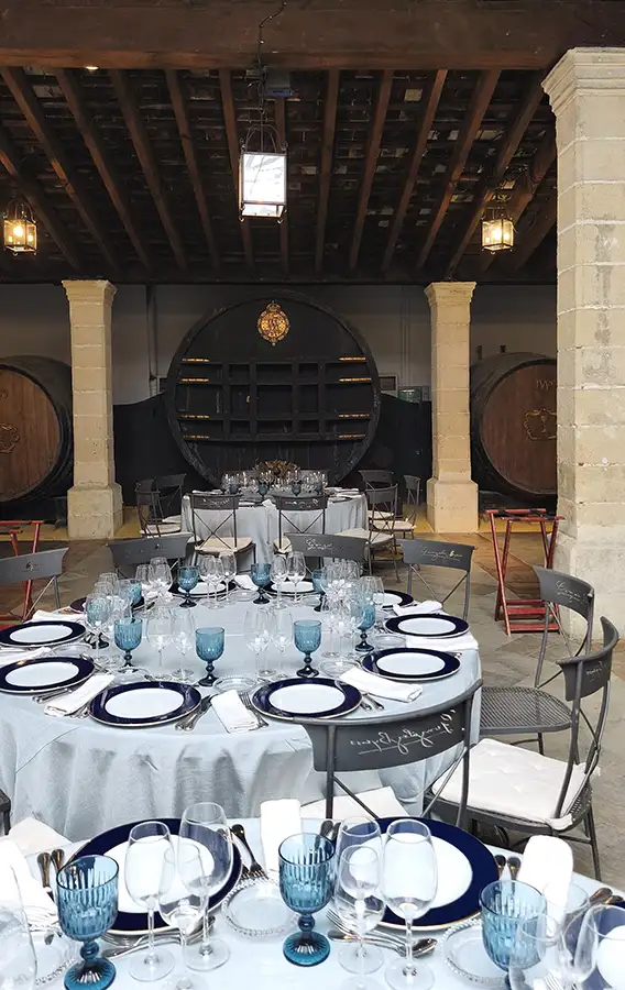 Mesa preparada para degustação harmonizada de xerez na bodega González Byass, tonel El Cristo ao fundo
