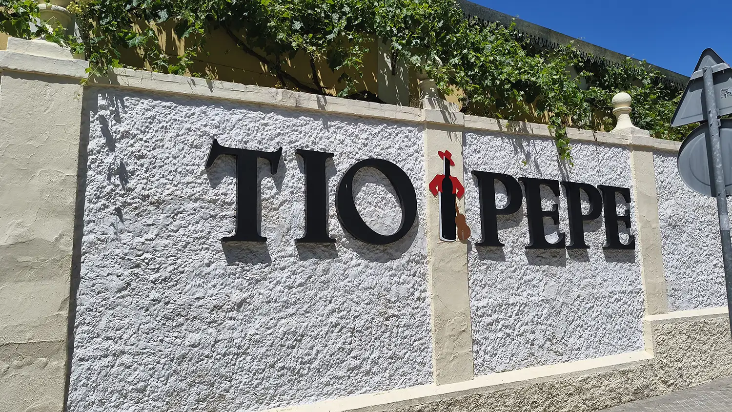Letreiro Tio Pepe na entrada da vinícola González Byass em Jerez de la Frontera, fachada branca com plantas