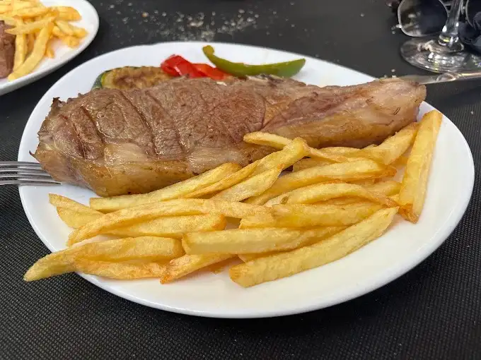 Prato de presa ibérica grelhada com batatas fritas e pimentos em um restaurante de La Alberca