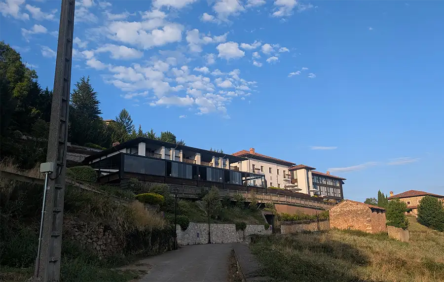 Fachada do Puebloastur Eco Resort vista do caminho de baixo, com o terraço envidraçado sobre a encosta