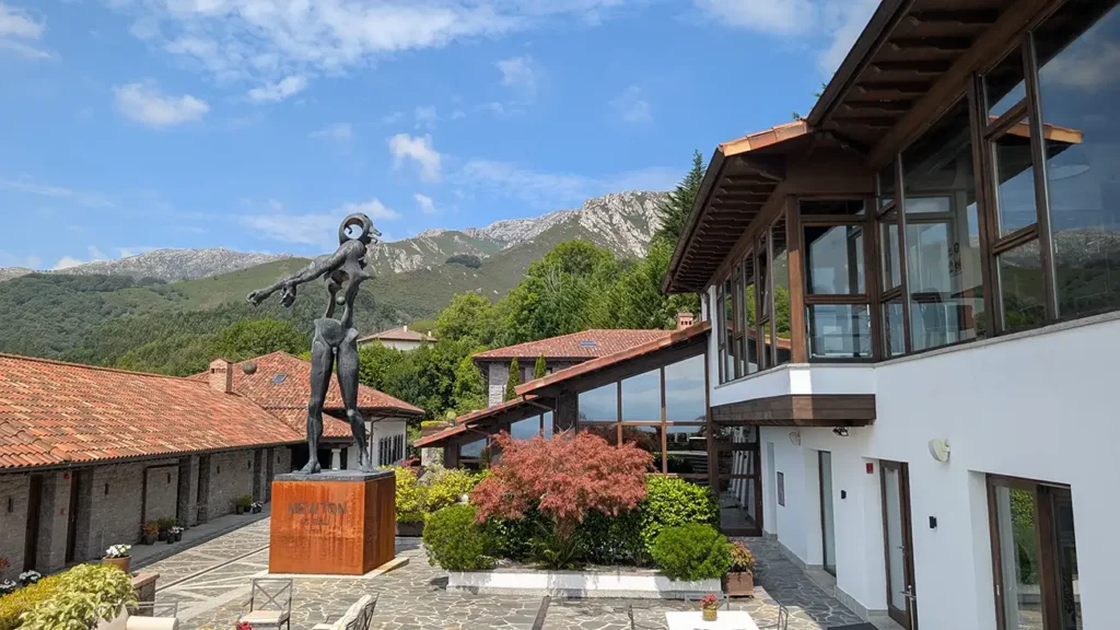 Praça central do Puebloastur com a escultura Newton de Dalí e as montanhas ao fundo