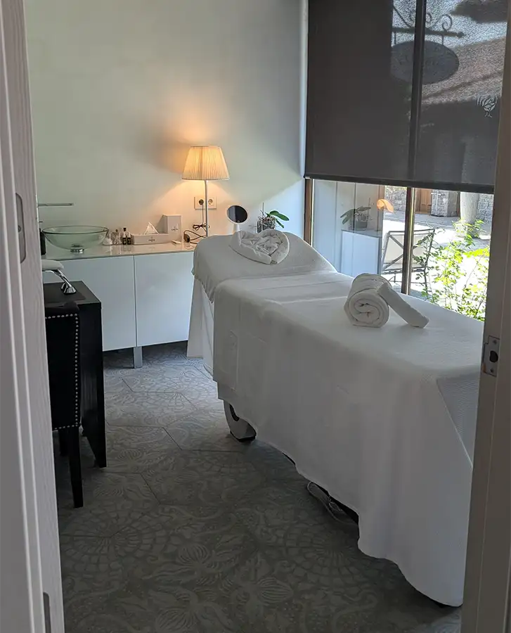 Sala de massagem do spa do Puebloastur com maca e janela voltada para o exterior