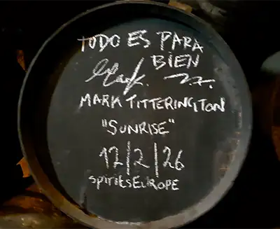 Fundo de barril de carvalho escuro com uma mensagem assinada a giz branco por Mark Titterington e uma data.