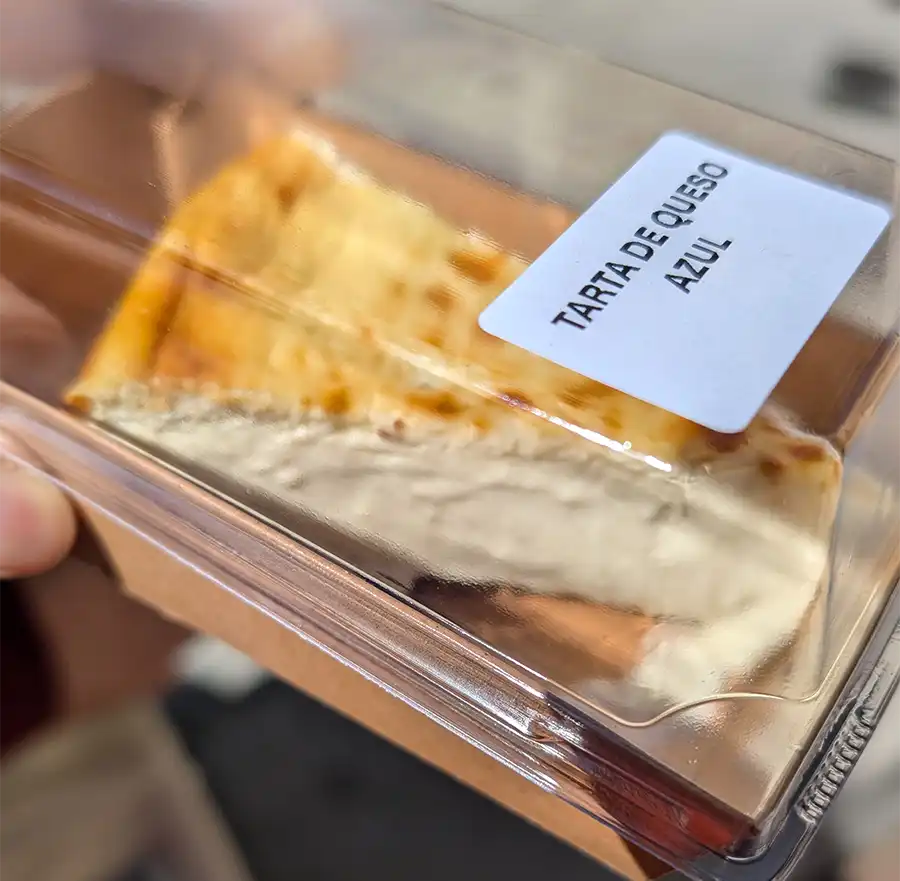Fatia de cheesecake de queijo azul em embalagem transparente com etiqueta "Tarta de queso azul"