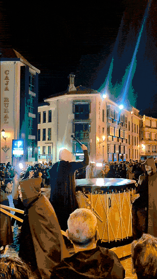 Homem encapuzado tocando tambor gigante em desfile do Festival de las Ánimas em Soria.